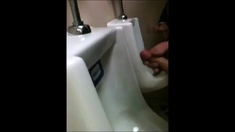 two slim dicks getting wanked at the urinals