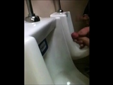 two slim dicks getting wanked at the urinals